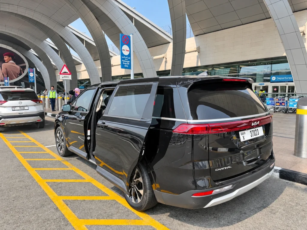 Comfort Kia Carnival outside airport departures; edited preview